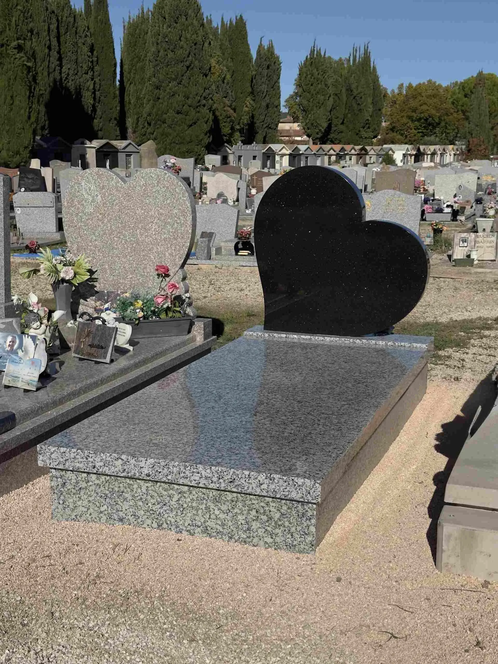 Monument funéraire avec une stèle sculptée en forme de cœur noir poli.