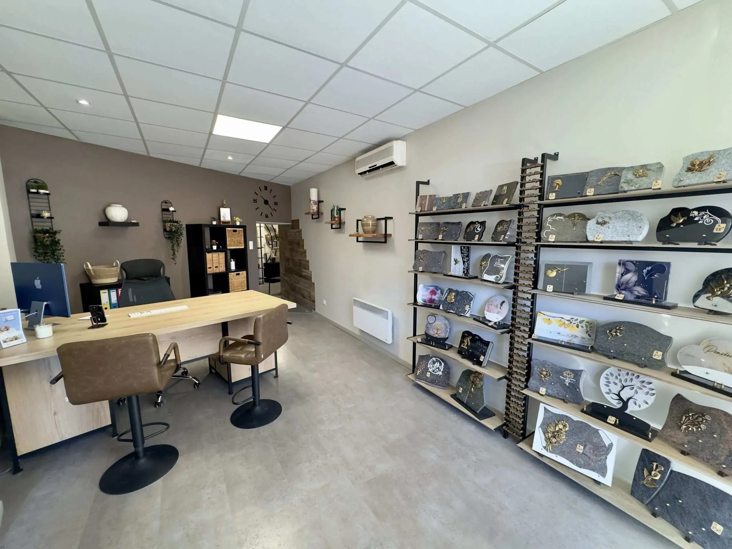 Bureau d'accueil de pompes funèbres avec exposition de plaques funéraires.