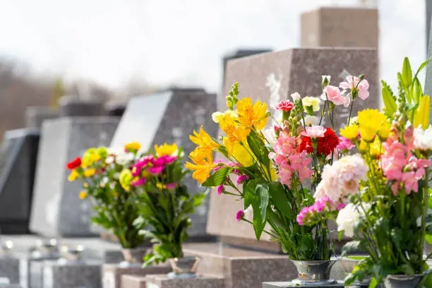 Composition de fleurs fraîches et colorées déposée sur une stèle funéraire.