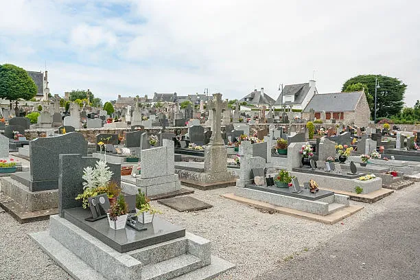 Cimetière paysager comportant un alignement de tombes et de stèles en granit.